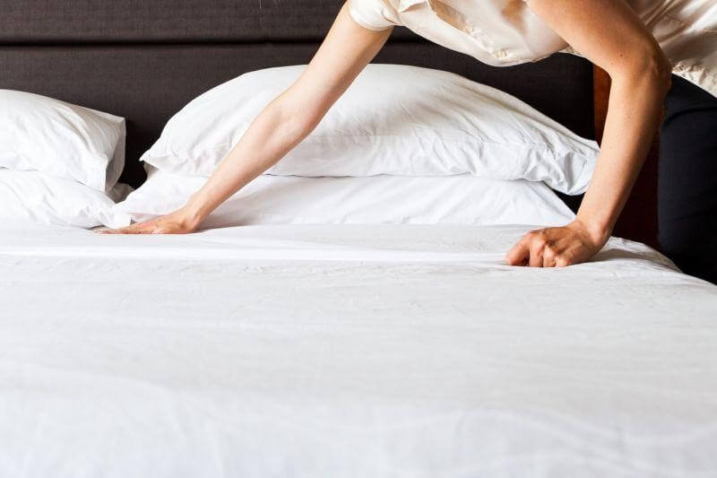 Eine Person bezieht ein Bett